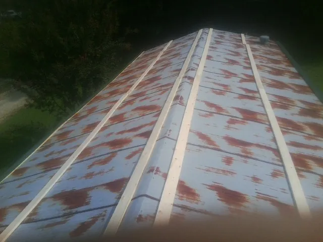 Rusted metal roof panels with new wood purlins before replacement — Storm Damage Roof Repair in Brandeis by Roofing Brothers